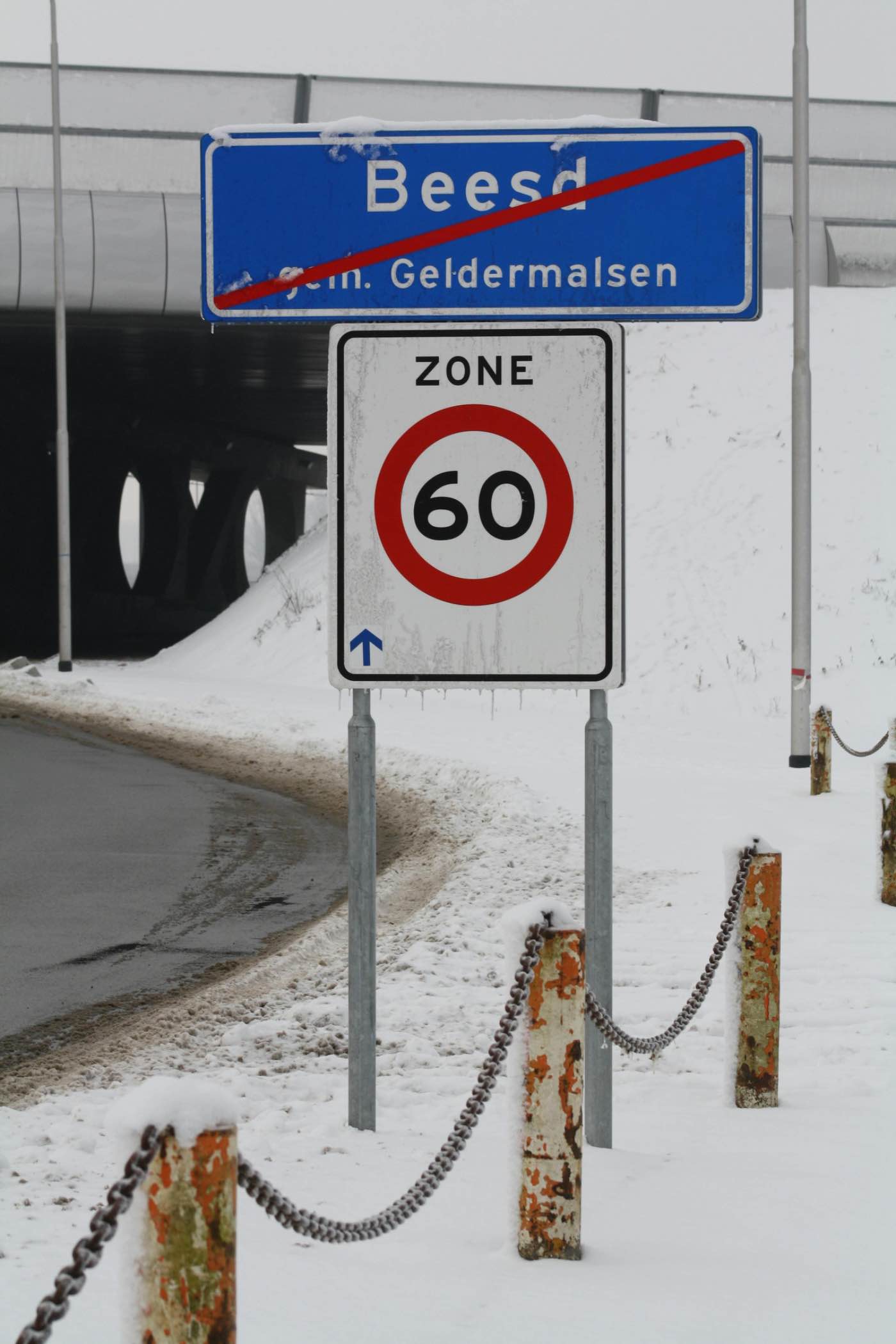 Kombord einde bebouwde kom en zone 60 snelheidsbord in winterlandschap